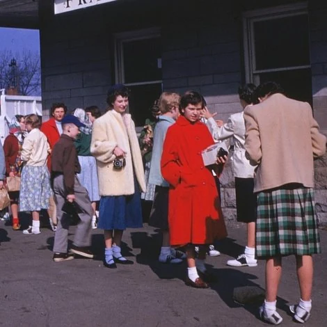 Fashions of 1955 are visible at a suburban Chicago train station.