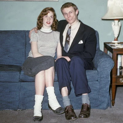 A teenage couple poses for a photo in the living room.
