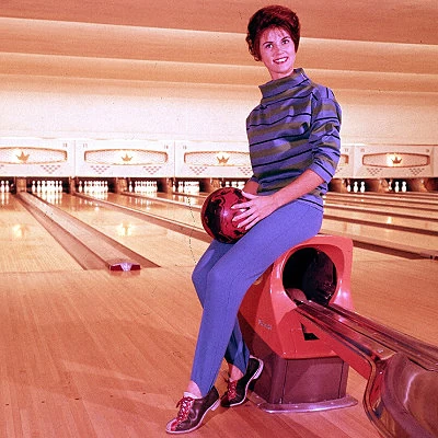 Model poses in a bowling alley.