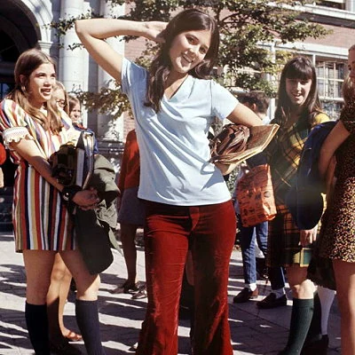 Teen girls ham it up for the photographer outside their high school.