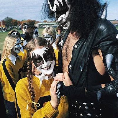 The rock band Kiss agreed to play at the high school homecoming dance in Cadillac, Michigan in 1975. Gene Simmons shown with the cheerleading squad.