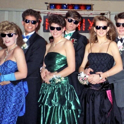 A group of high school teens wear their sunglasses at night in a 1990 prom photo.