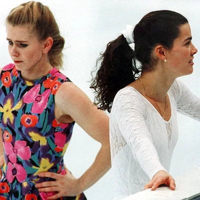 Figure skater Nancy Kerrigan (right) is injured in an assault as she leaves practice for the U.S. Figure Skating Championships. The attack is planned by fellow figure skater Tonya Harding's ex-husband Jeff Gillooly with the intent of keeping Kerrigan out of the championship and the upcoming Winter Olympics. Harding (at left) is implicated in the attack, but pleads guilty to a lesser charge.